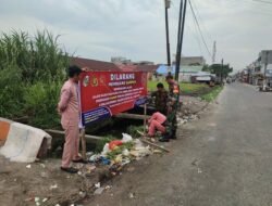 Babinsa LBT Bersama Perangkat Kelurahan Pasang Spanduk Larangan Buang Sampah