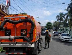 Babinsa Sukamulia Dampingi Petugas DLHK Bersihkan Jalan